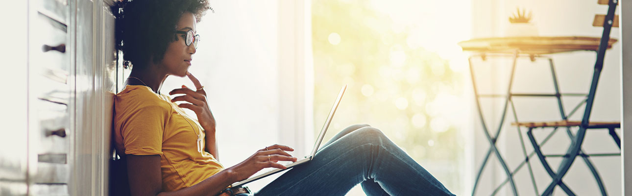 Young woman using computer in kitchen