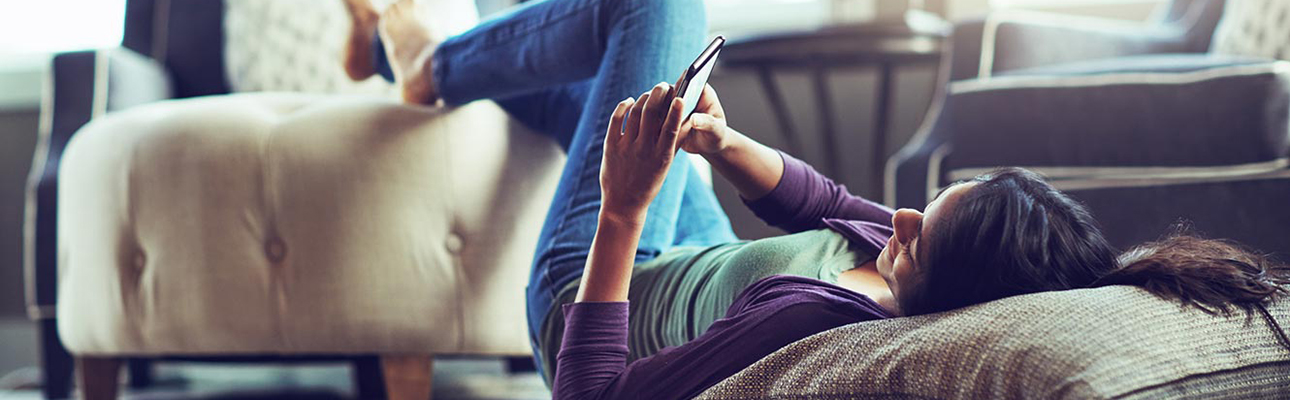 Woman lying on floor looking at phone