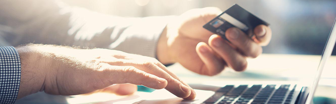 Close-up of man using card to shop online