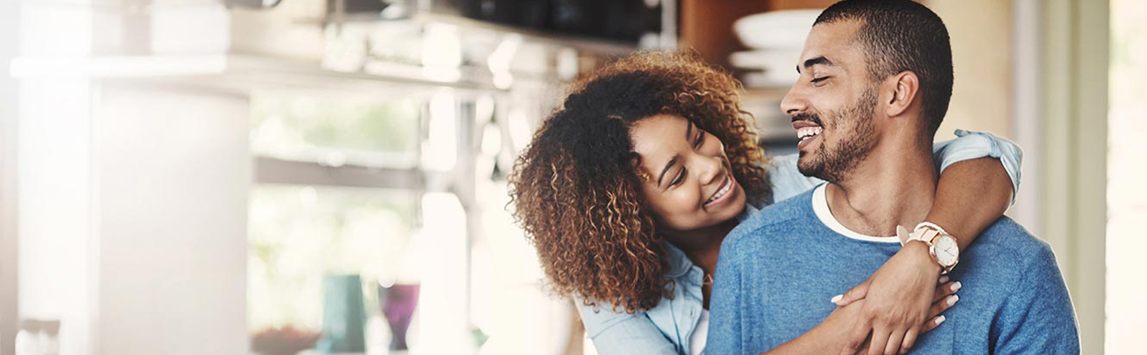 Happy couple embracing in kitchen